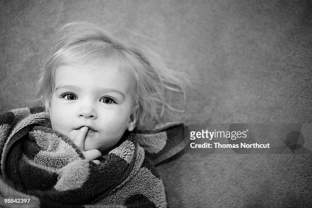 toddler girl laying on floor, wrapped in towel. - 354 stock-fotos und bilder