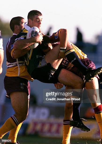 Kyle Warren of of the Cowboys is up-ended by Carl Webb and Dane Carlaw of the Broncos during the round fourteen NRL match between the Brisbane...