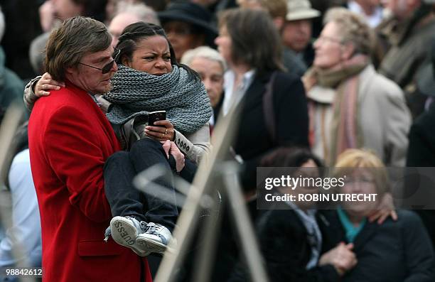 Man carries a woman following a mass panick amid a rumour at the National Remembrance on the Dam in Amsterdam, on May 4, 2010 . Several man, also...