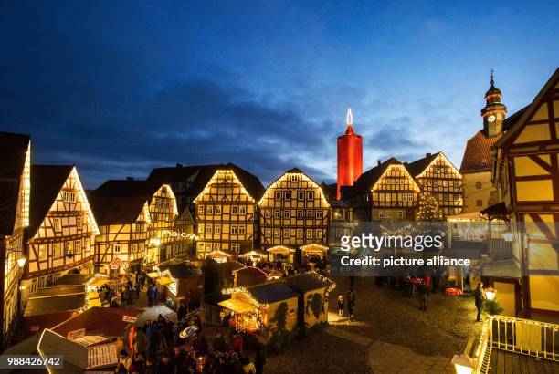 Dpatop - The world's largest candle shines on the Christmas market in Schlitz, Germany, 02 December 2017. A 36 metre high stone tower is wrapped in a...