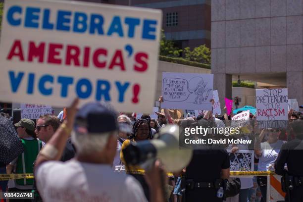 Pro-Trump counter demonstrator holds a sign toward protesters decrying Trump administration immigration and refugee policies on June 30, 2018 in Los...