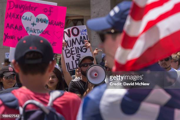 Pro-Trump counter demonstrators and protesters decrying Trump administration immigration and refugee policies face off on June 30, 2018 in Los...
