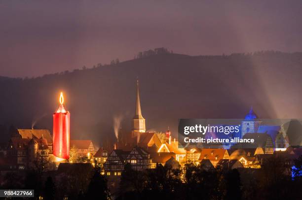 The world's largest candle shines at the Christmas market in Schlitz, Germany, 02 December 2017. A 36 metre high stone tower is wrapped in a red...