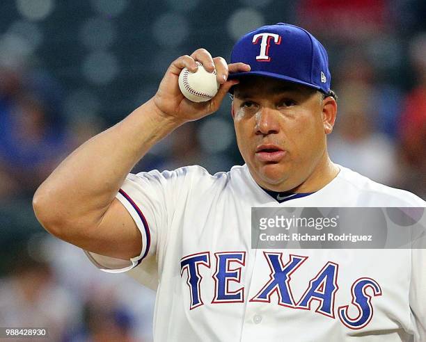 Bartolo Colon of the Texas Rangers adjusts his hat during the second inning of a baseball game against the Chicago White Sox at Globe Life Park in...