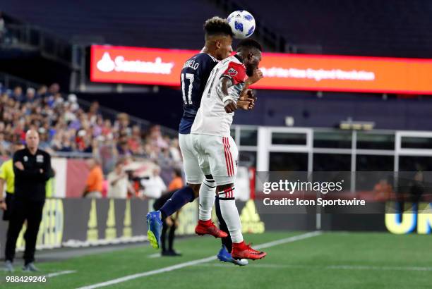 New England Revolution forward Juan Agudelo beats DC United defender Oniel Fisher in the air during a match between the New England Revolution and DC...