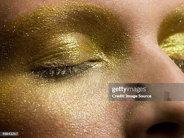 female eyes covered in gold make up - glitter eyeshadow stock pictures, royalty-free photos & images