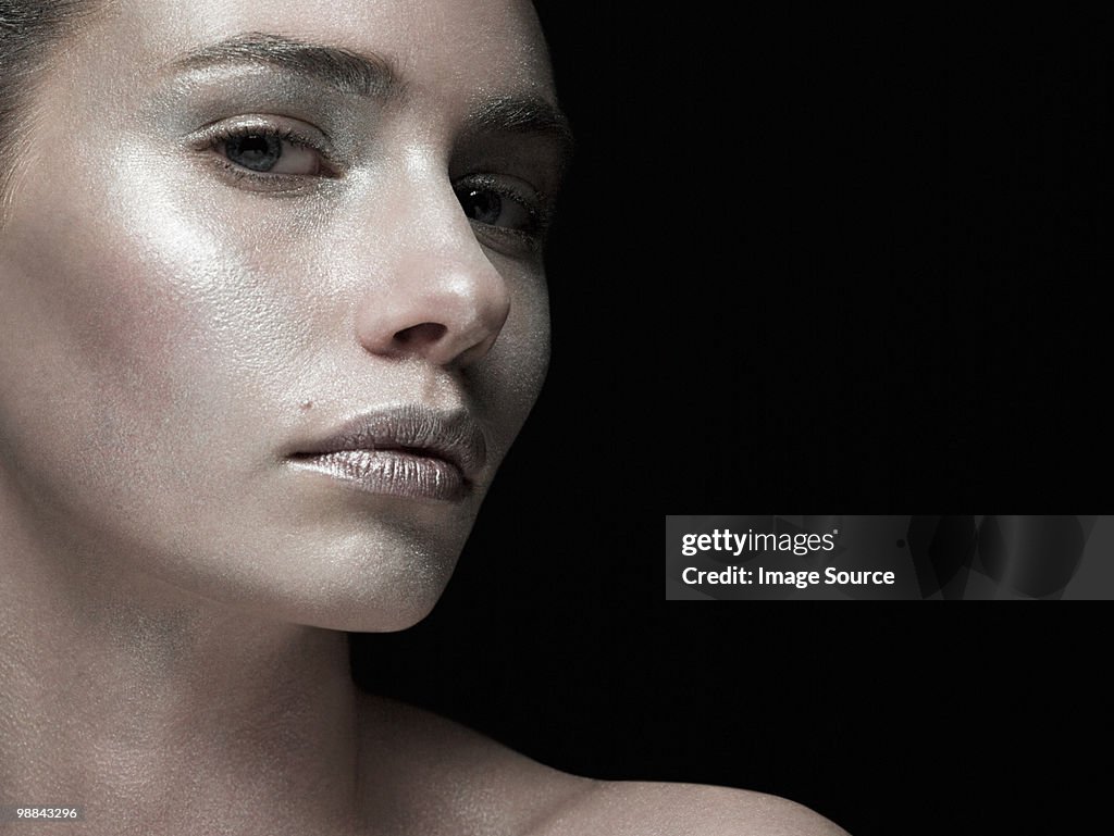Young woman covered with silver make up
