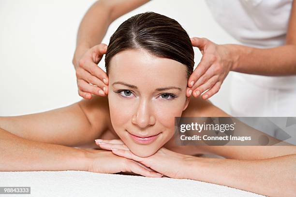 woman having face massage - massage table white background stock pictures, royalty-free photos & images