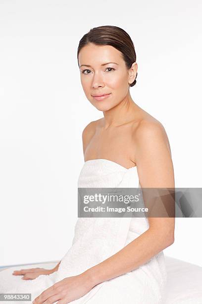 young woman wearing towel - massage table white background stock pictures, royalty-free photos & images