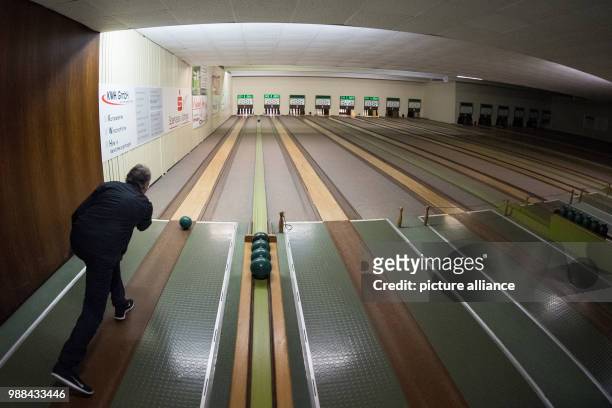 Bowling player takes a turn at hitting the pins of a fully automated bowling alley with a bowling ball at the bowling centre in Bovenden, Germany, 1...