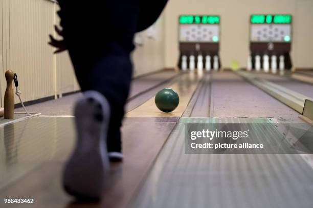 Bowling player takes a turn at hitting the pins of a fully automated bowling alley with a bowling ball at the bowling centre in Bovenden, Germany, 1...