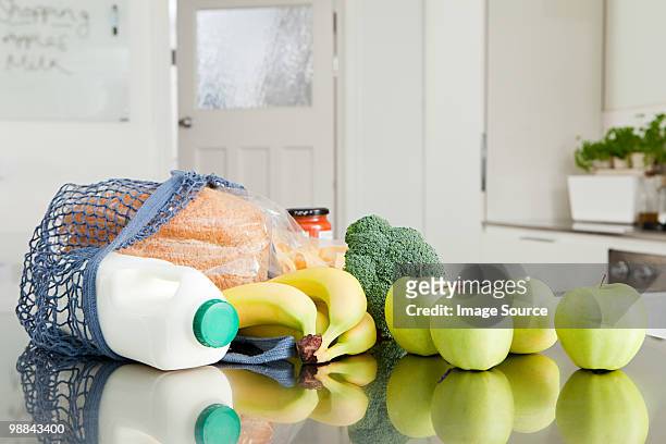 groceries on kitchen counter - grocery bag stock pictures, royalty-free photos & images