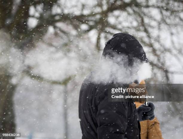 Man exhaling the vapor from his e-cigarette on the Lohrberg in Frankfurt am Main, Germany, 03 December 2017. It snowed the whole morning in the...