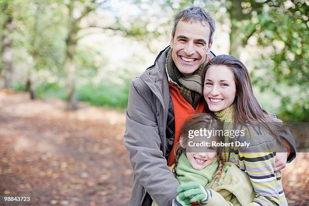 smiling family hugging outdoors - robert a daly bildbanksfoton och bilder