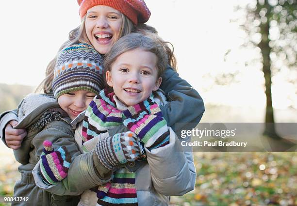 playful children smiling outdoors in autumn - autumn friends coats stock pictures, royalty-free photos & images