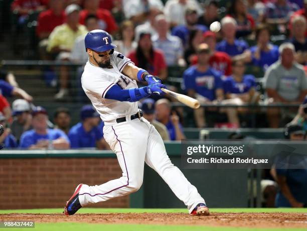 Robinson Chirinos of the Texas Rangers hits a three-run double in the fourth inning of a baseball game against the Chicago White Sox at Globe Life...