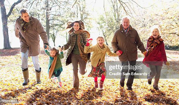 grande família correndo em parque no outono - family walking sam edwards - fotografias e filmes do acervo