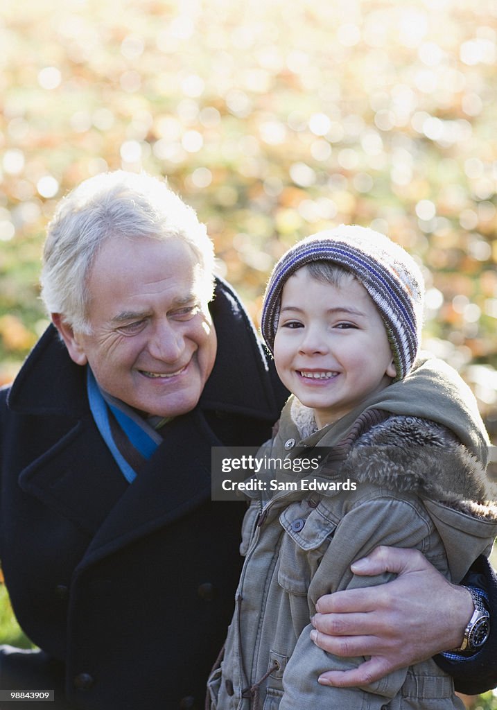 Grandfather hugging grandson outdoors