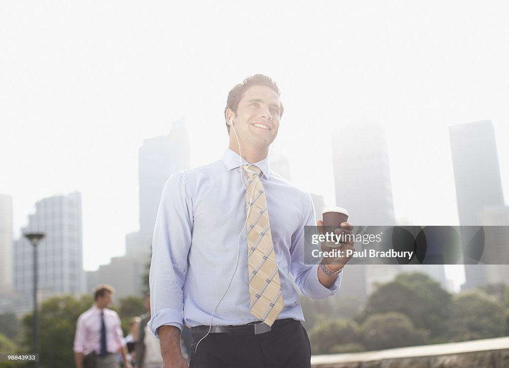 Businessman carrying coffee outdoors