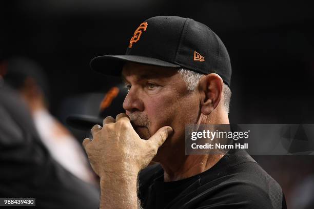 Manager Bruce Bochy of the San Francisco Giants looks on from the dugout during the second inning against the Arizona Diamondbacks at Chase Field on...