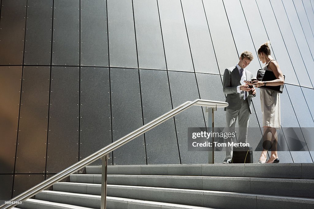 Business people talking at top of steps outdoors
