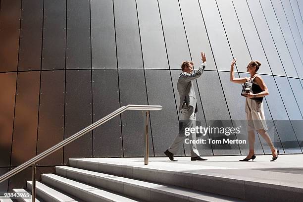 business people high fiving outdoors - australian cup day stock pictures, royalty-free photos & images