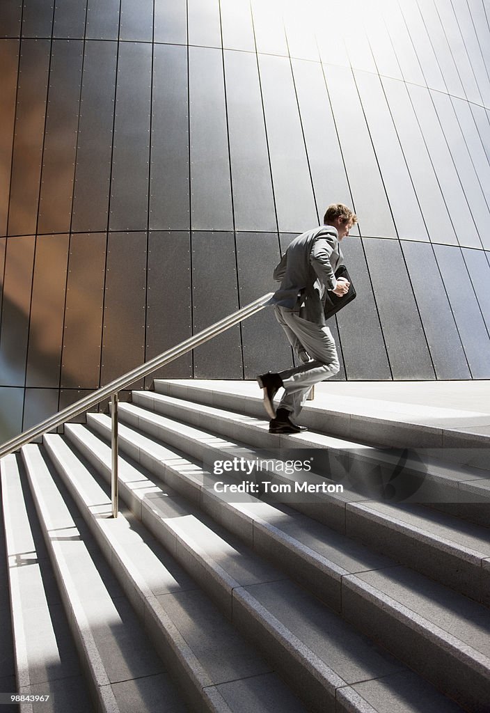 Businessman rushing up steps outdoors