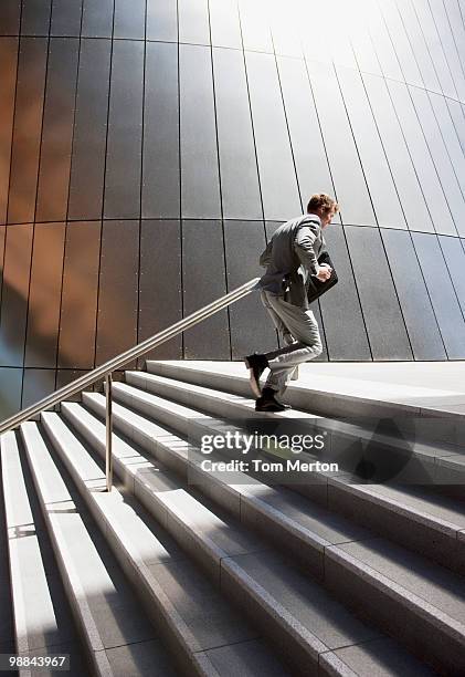 businessman rushing up steps outdoors - staircase 個照片及圖片檔