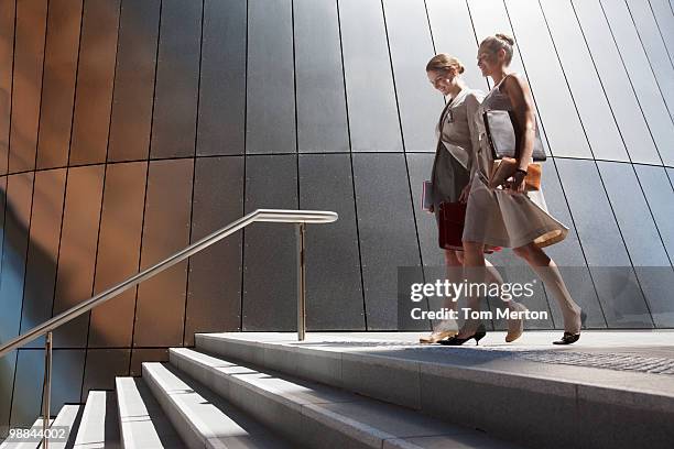 businesswomen andar para baixo passos ao ar livre - bem vestido imagens e fotografias de stock