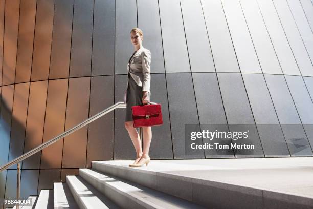 businesswoman standing at top of steps outdoors - low angle view of silhouette palm trees against sky stockfoto's en -beelden