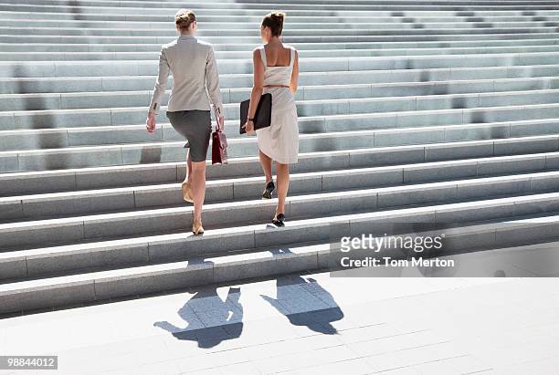 businesswomen walking up steps outdoors - staircase stock pictures, royalty-free photos & images