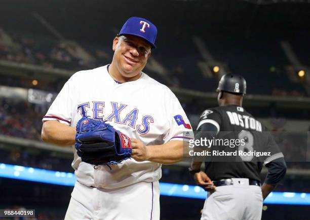 Bartolo Colon of the Texas Rangers smiles after gettting his glove back after tossing it to Daryl Boston of the Chicago White Sox on the way to the...