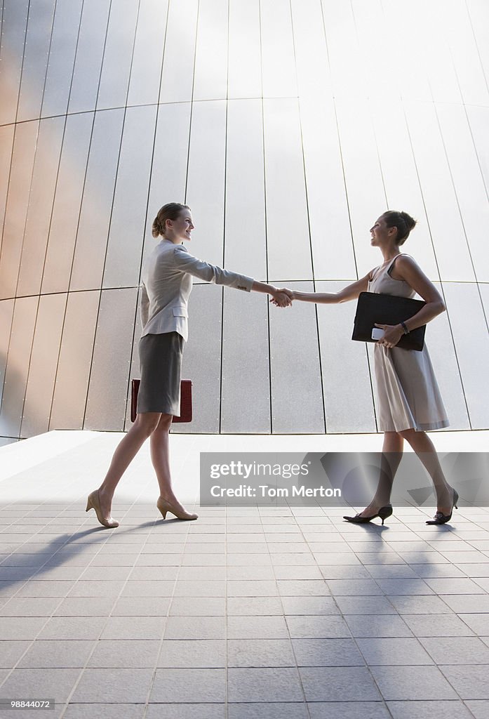 Businesswomen shaking hands outdoors