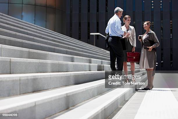 business people standing on steps outdoors - formal businesswear stock pictures, royalty-free photos & images
