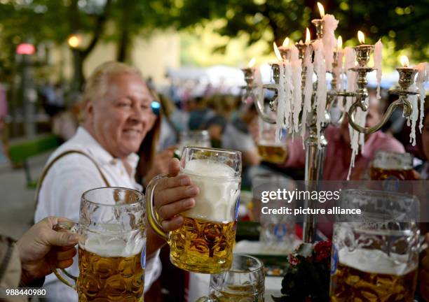 July 2015, Germany, Munich: A group of men sitting in the beergarden at the Chinese Tower in the English garden and during the traditional...