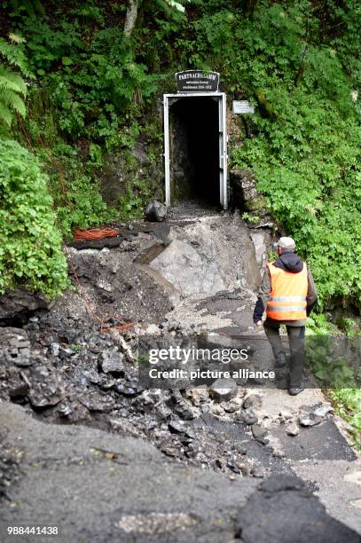 June 2018, Germany, Garmisch-Partenkirchen: Roland Achnter, the manager responsible for the gorge of Garmisch-Partenkirchen, walks on a heavily...