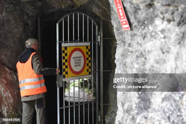 June 2018, Germany, Garmisch-Partenkirchen: Roland Achnter, the manager responsible for the gorge of Garmisch-Partenkirchen, opens the gate of the...