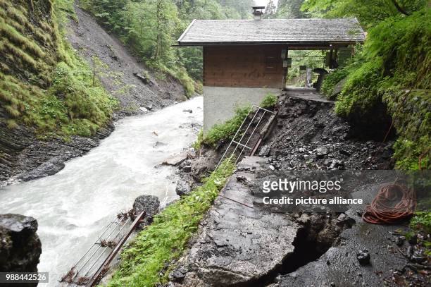 June 2018, Germany, Garmisch-Partenkirchen: The path behind the old ticket-booth of the Partnach Gorge is torn away. The tourist destination remains...