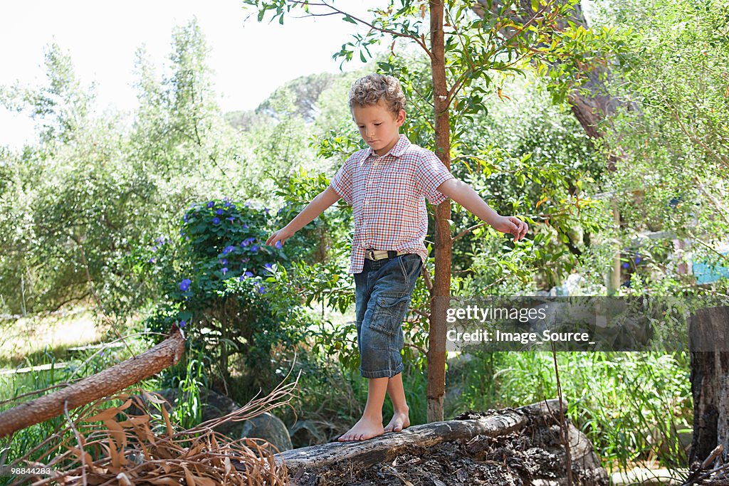 Boy walking on log
