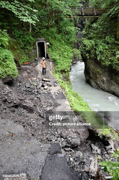 June 2018, Germany, Garmisch-Partenkirchen: Roland Achnter, the manager responsible for the gorge of Garmisch-Partenkirchen, walks on a heavily...