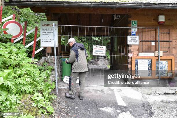 June 2018, Germany, Garmisch-Partenkirchen: Roland Achnter, the manager responsible for the gorge of Garmisch-Partenkirchen, closes off the Partnach...