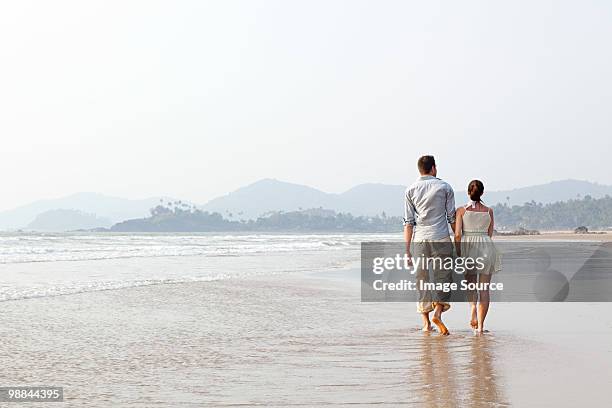 couple walking in the sea - indian honeymoon couples stock pictures, royalty-free photos & images