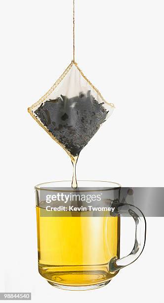 close up of cup of tea and dripping tea bag - tea bags stock pictures, royalty-free photos & images