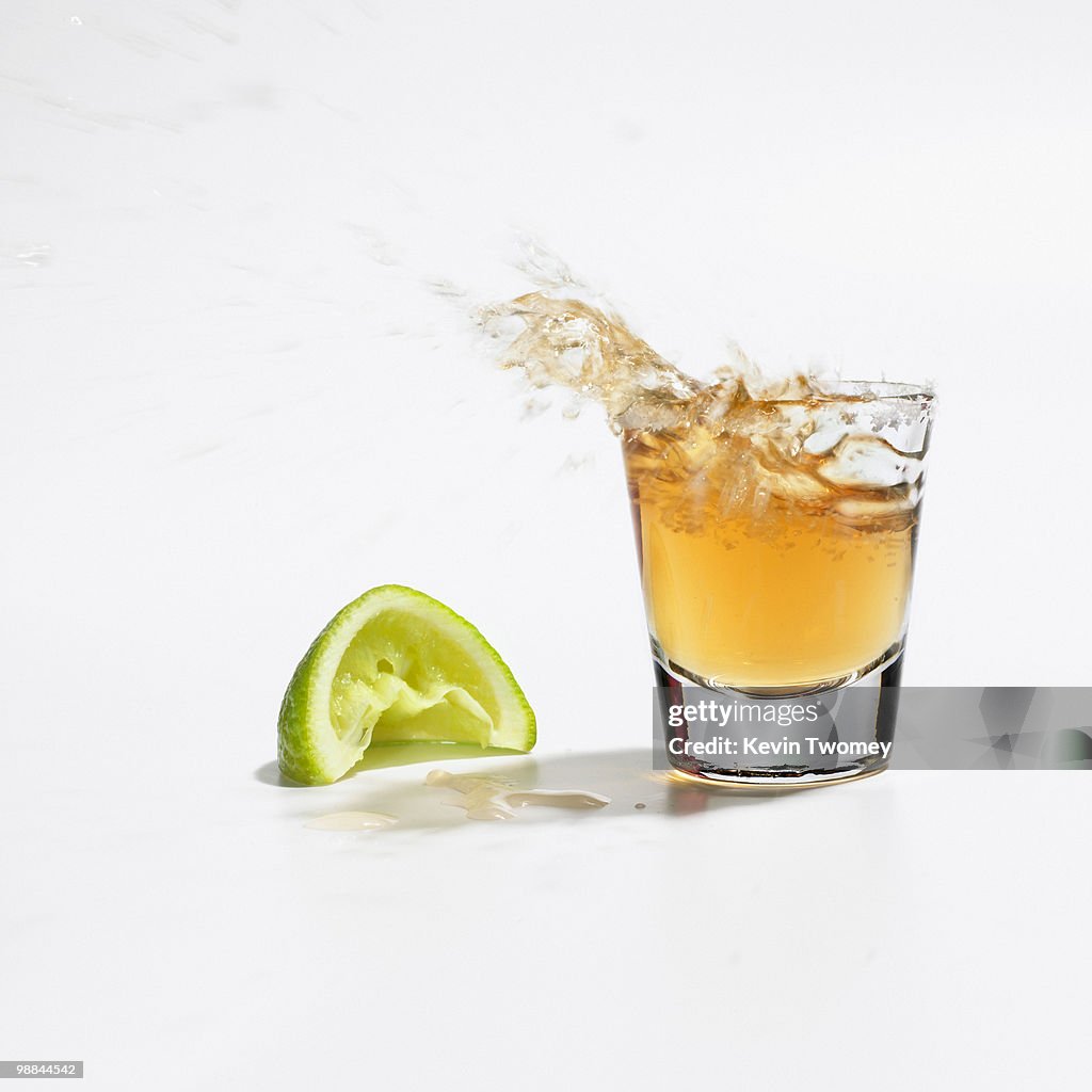 Close up of tequila splashing out of glass