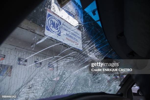 Smashed car windows are seen were residents of the Purepecha indigenous community attacked the headquarters of "Mexico al Frente" coalition of the...