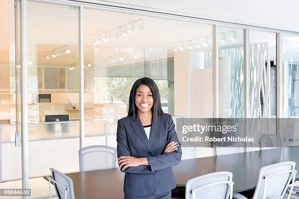 smiling businesswoman standing in office conference room - robert moreno fotografías e imágenes de stock