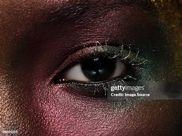female eye covered in metallic make up - eye make up stock pictures, royalty-free photos & images