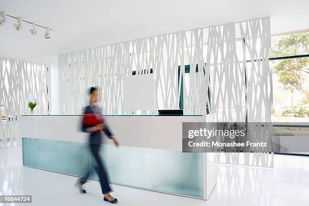 businesswoman rushing through office lobby - bewegungsunschärfe büro stock-fotos und bilder