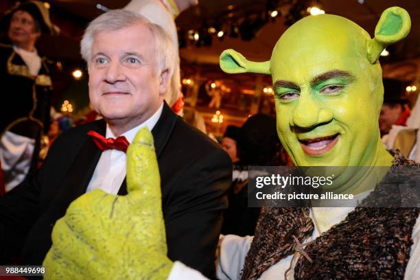 File picture dated 21 February 2014 showing the state of Bavaria's Minister of Finance, Markus Soder , posing in costume as "Shrek" next to Bavarian...