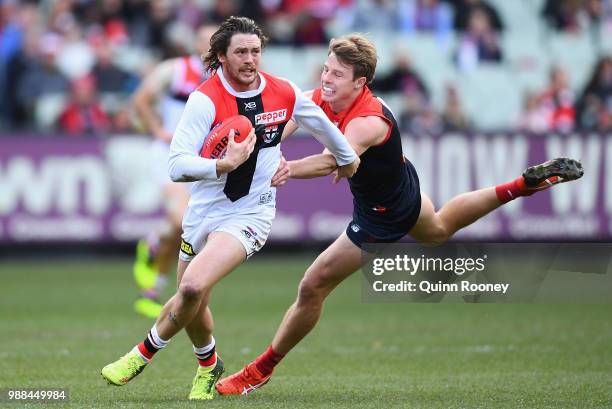 Jack Steven of the Saints is tackled by Mitch Hannan of the Demons during the round 15 AFL match between the Melbourne Demons and the St Kilda Saints...